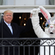 President Donald Trump lifts the Easter Bunny’s hand on the Truman Balcony during the 140th annual Easter Egg Roll on the South Lawn of the White House on April 2, 2018, in Washington, D.C.